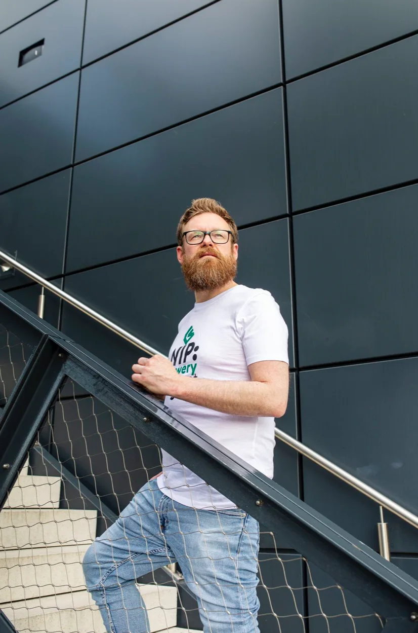 Carsten Sachse auf einer Außentreppe vor dunkler Fassade mit wwwery-Shirt — Webdesigner aus Oberursel