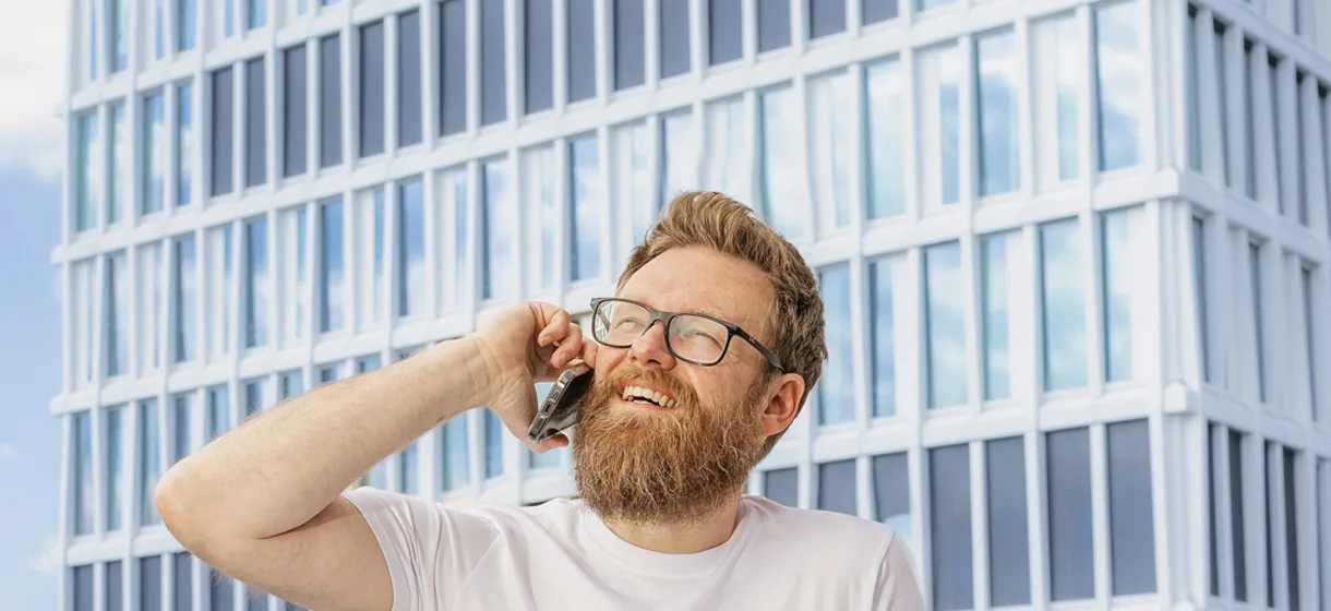 Carsten Sachse am Telefon vor Frankfurter Bürohochhäusern — direkter Ansprechpartner für die Website-Betreuung, kein Callcenter