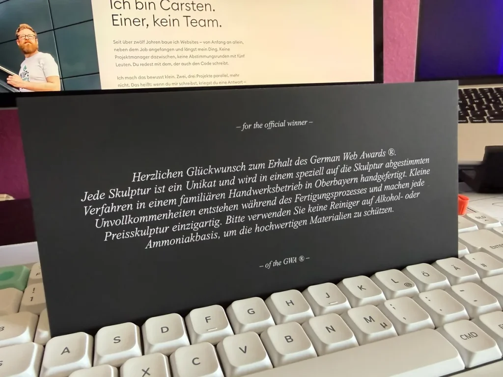 Rückseite der Begleitkarte des German Web Awards 2026 mit dem Glückwunschtext des Ausrichters an den offiziellen Preisträger