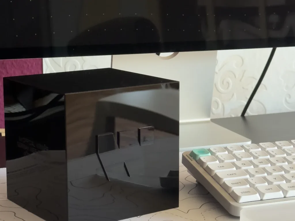 Preisskulptur des German Web Awards 2026: schwarzer Glaswürfel mit eingraviertem Logo, auf dem Schreibtisch von Webdesigner Carsten Sachse in Oberursel
